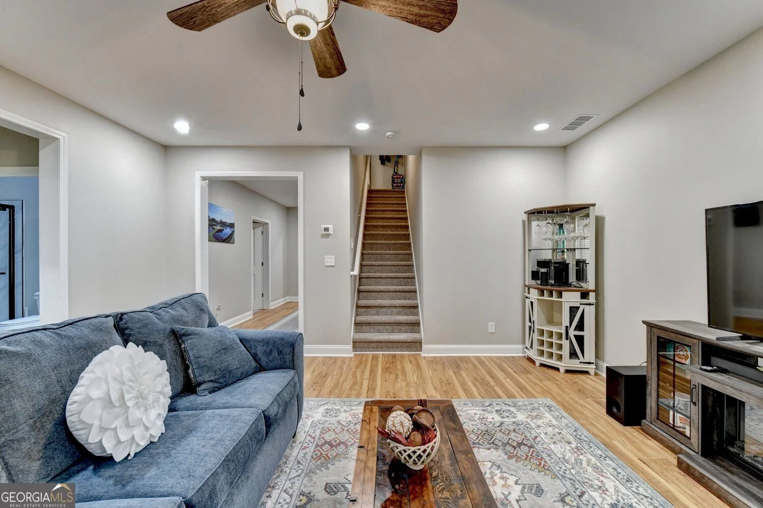 Finished basement living area with windows and stair access